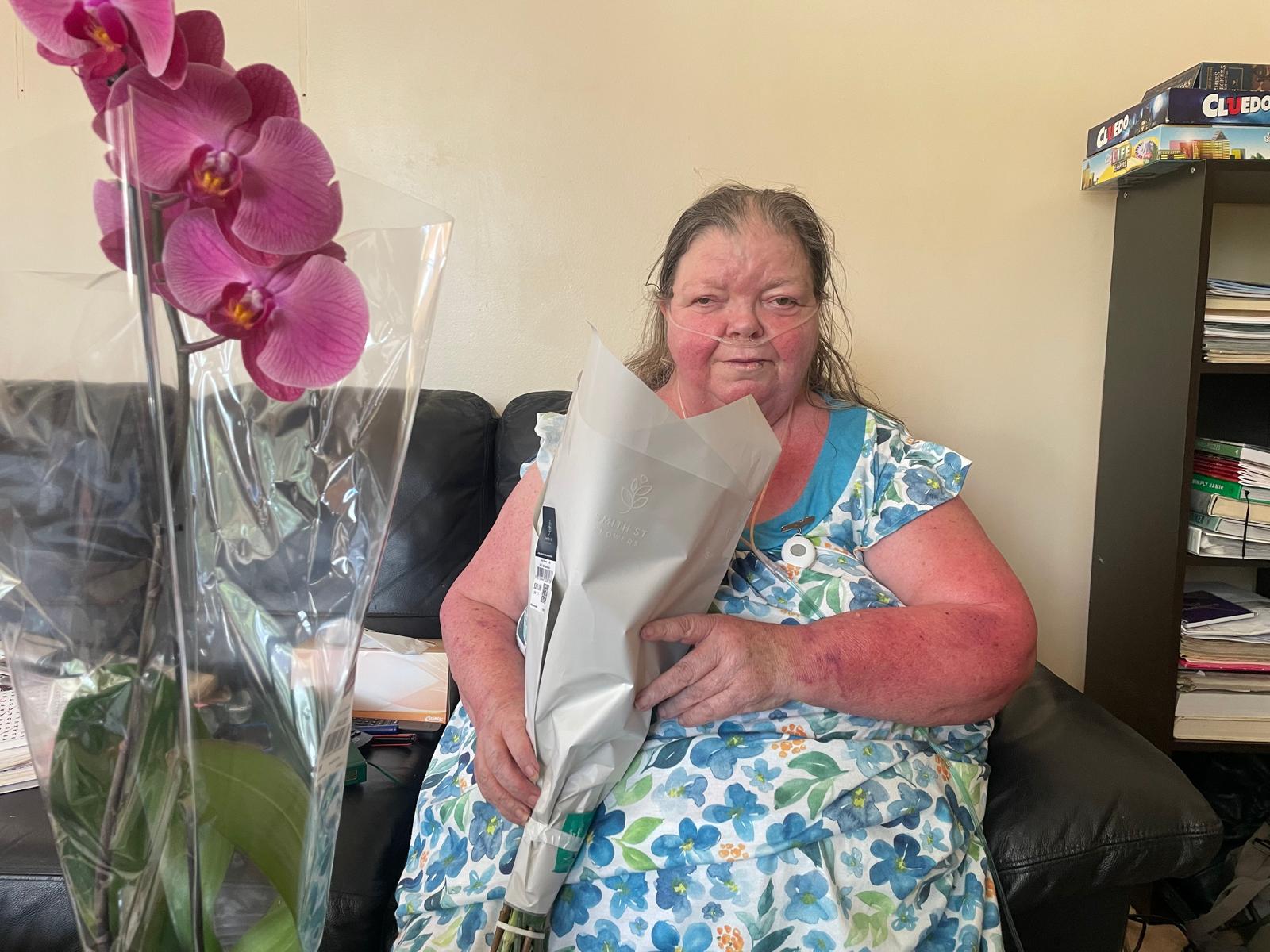 An ACT Jubilant participant at home with a gift of flowers